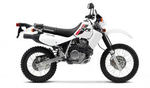THIRTY YEARS . . . AND COUNTING- Everyone knows that a Honda XR650L is the one bike you can always count on, no matter how gnarly the road or trail.
Everything about this bike is rugged, simple, and proven: the 644cc air-cooled single-cylinder engine, the strong steel frame, the long-travel suspension. Electric starting makes getting underway a snap—same for restarts in rocky trail sections. It’s fully street legal, and roomy enough to carry a passenger. And while the 2022 XR650L is still as tough as an anvil, for 2022 it has a new, fresh, contemporary look thanks to a total graphic makeover. Black rims match the black seat, tool bag, and fork gaiters; the white-on-white bodywork has a super-clean look; and the new tank graphics pay tribute to the 650’s Honda XR heritage. Whether you’re using it for off-road adventures or as the ultimate post-apocalyptic commuter, the XR650L has never looked this good.